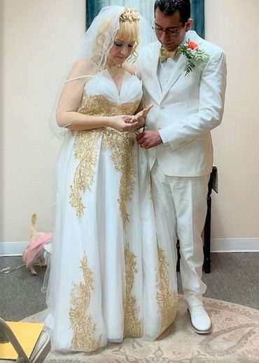 Felicia & Hugo, both dressed formally all in white, strike a pose prior to their ceremony