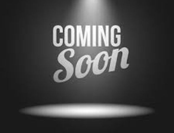 Black background with 'Coming Soon' text illuminated by spotlight.