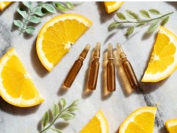 orange slices with vials of vitamin c