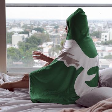 woman wearing a retro philadelphia eagles kelly green hoodie snuggle blanket in bed