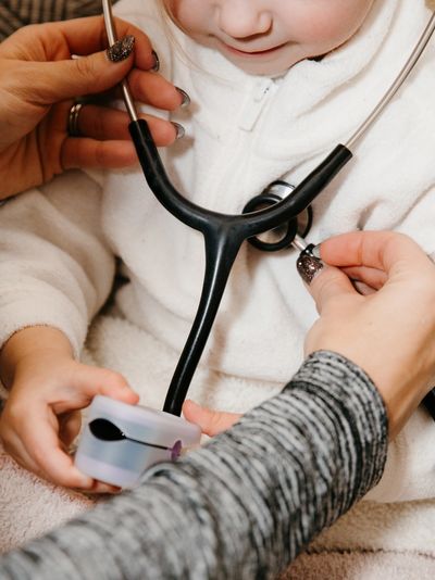 Child playing doctor with a stethoscope and pulse oximeter.