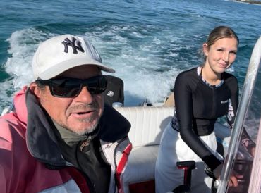 Two people enjoying a boat ride on a sunny day.