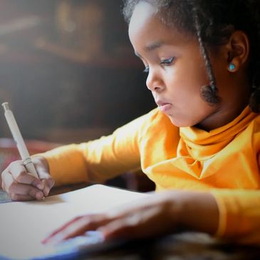 Young girl focused on writing in a notebook.