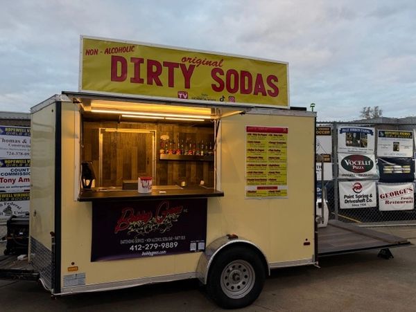A food trailer selling original non-alcoholic dirty sodas at dusk.