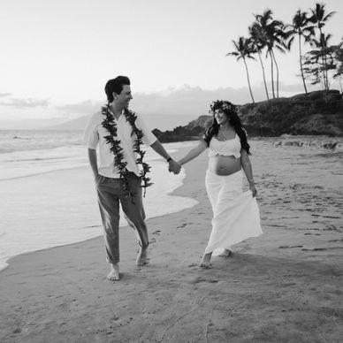 Couple holding hands walking on the beach.