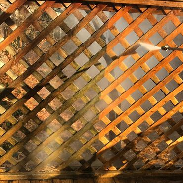 Pressure washing wooden lattice. Transformative side by side view.