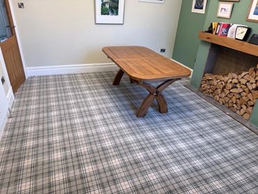 Wooden table on checkered carpet near fireplace.