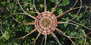 Weaved willow flower against a holly hedge background