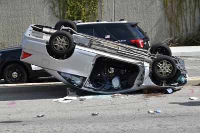 Car flipped upside down with a police car in the background