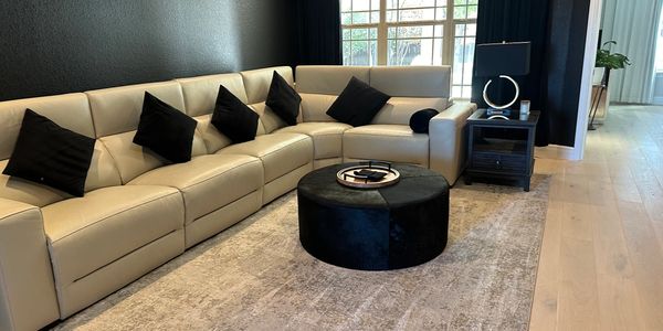 Modern beige sectional sofa with black pillows in a stylish living room.