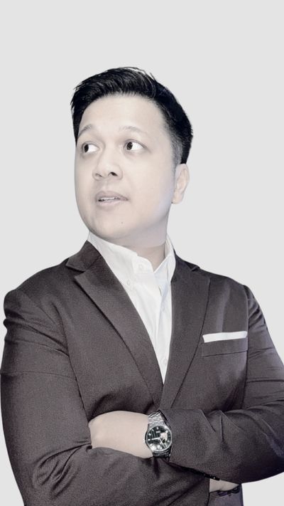 Man in a dark suit looking thoughtfully to the side.