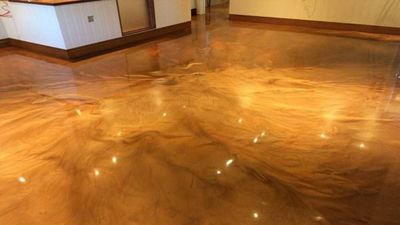 Shiny, polished wooden floor reflecting ceiling lights in an empty room.