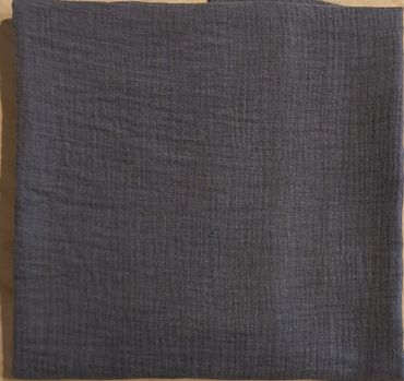 A folded dark gray textured fabric on a light surface.