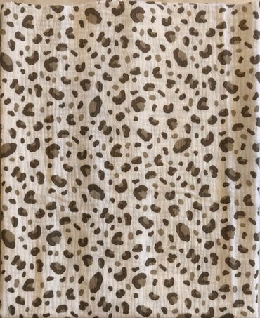 Close-up of fabric with beige and brown leopard print pattern.