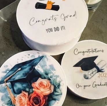 Three decorated graduation cakes with congratulatory messages and images.