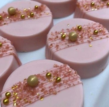 Pink round desserts decorated with golden and pink sprinkles.