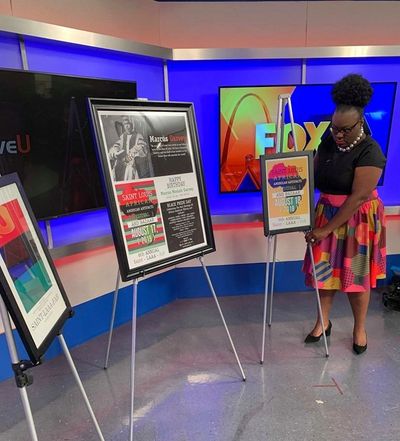 Woman adjusting a poster on an easel in a TV studio.