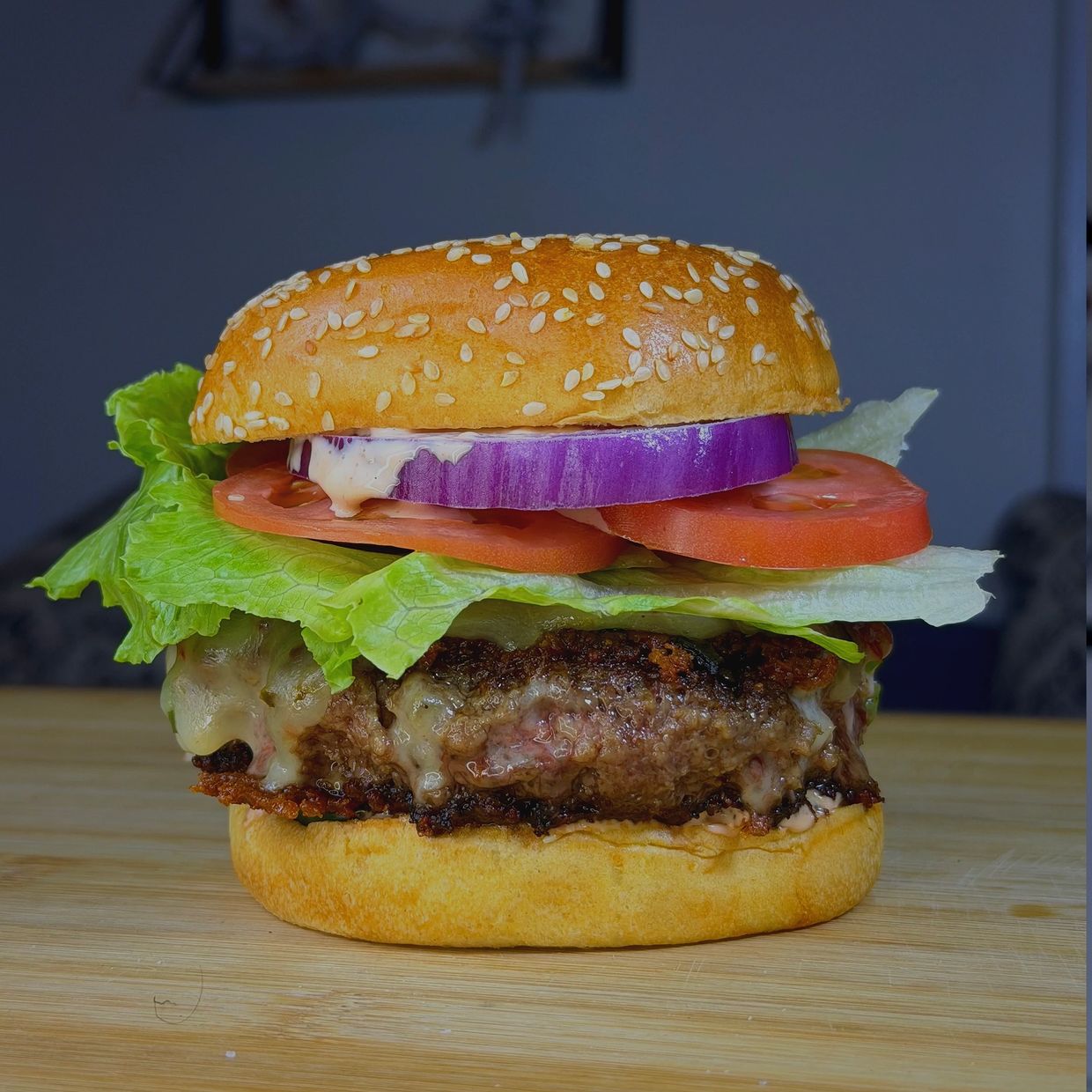 A cheeseburger with lettuce, tomato, and onion.