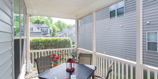 Cozy screened porch with table, chairs, and decorative lantern.