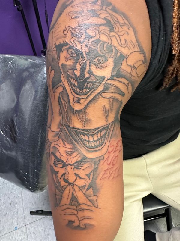 Black and gray Joker-themed illustrative tattoo with layered  portraits and detailed shading.