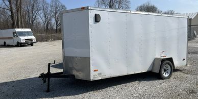 A trailer and box truck being stored outside.