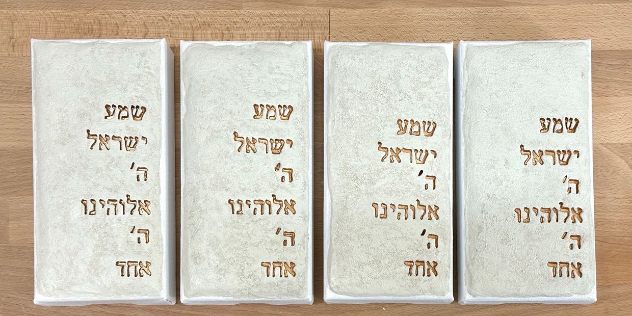 Four contemporary Judaica Shema artworks in textured clay with antique gold lettering.