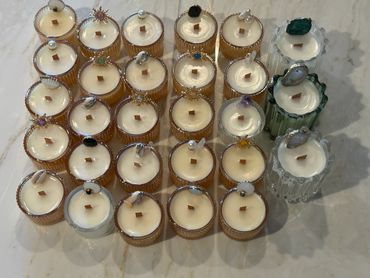 A collection of decorative candles with jeweled tops arranged on a marble surface.