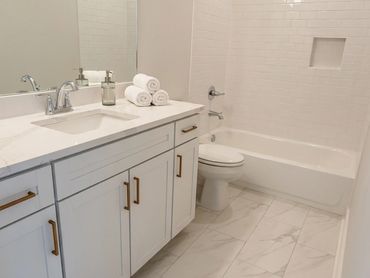 Bright and clean white bathroom with marble floor tiles.