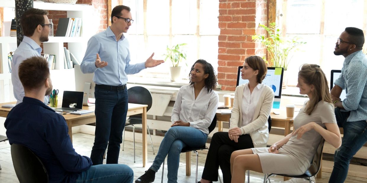 a man speaking in a office meeting 