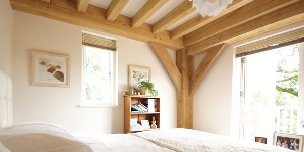 BAARN pre-fab house bedroom with exposed structural green oak frame including ceiling joists