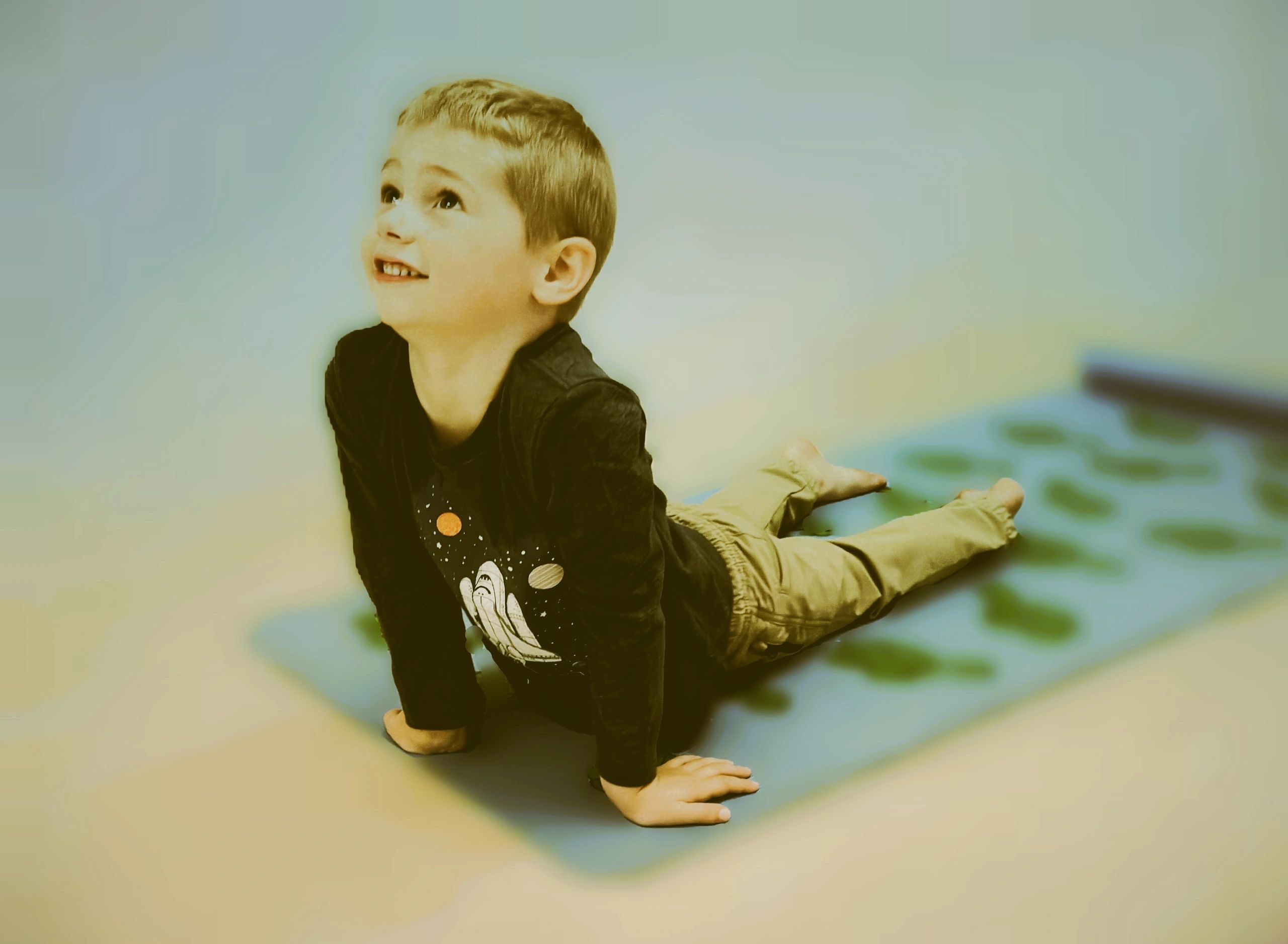 boy doing cobra pose in toddler time yoga class