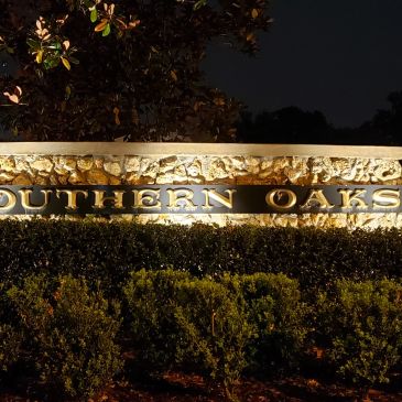 Illuminated Southern Oaks sign at night.