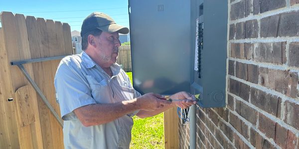 Brad Leland inspecting the breaker box on the exterior of a new construction home in Baytown.