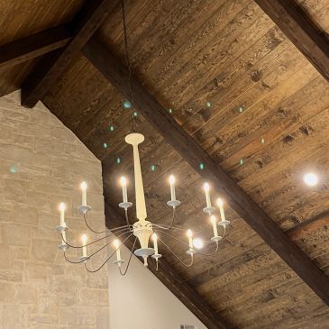 Elegant chandelier hanging from a rustic wooden ceiling.