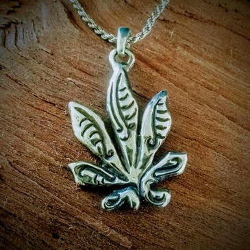 Image of a lost cast waxing silver pendant of a cannabis leaf from the Sterling Cache.