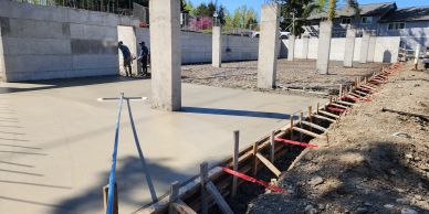 Concrete foundation work in progress with columns and formwork.