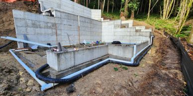 Concrete foundation walls with drainage pipes installed.