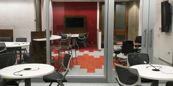 Modern conference room with tables, chairs, and screens.