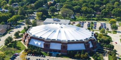 Aerial view of a circular stadium with a white roof.