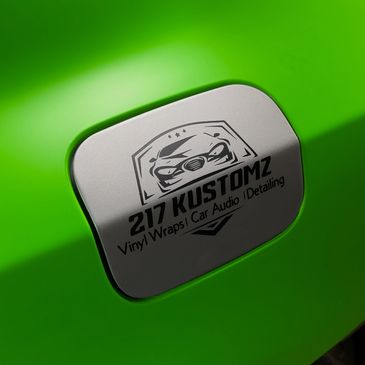 Close-up of a neon green car with a custom logo on the gas cap.