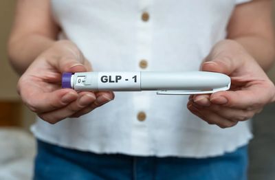 Person holding a GLP-1 injection pen.