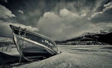 boat on ice wit sky and mountains in the back