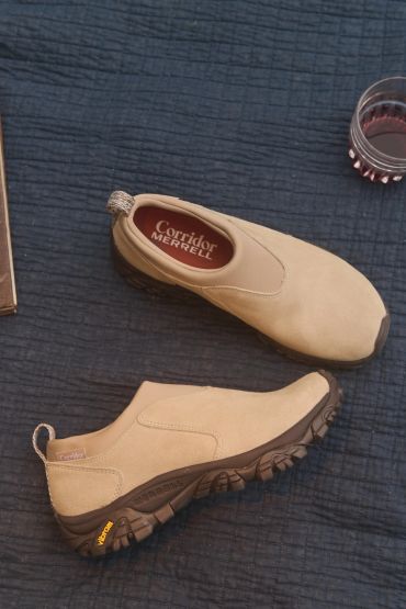 Beige Merrell Corridor slip-on shoes on a dark textured surface.