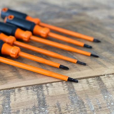 Orange and black screwdrivers on wood