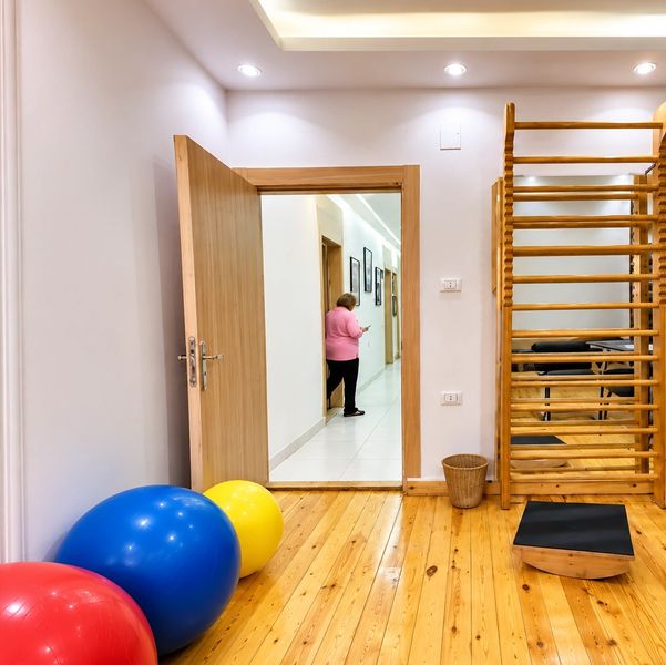 Gym with colorful exercise balls and wooden floor.