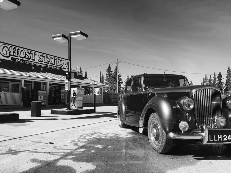 Black-and-white photo of the Ghost Station store front with a vintage car