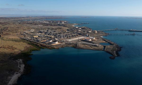 Industrial refinery complex by the coast with water and ships.