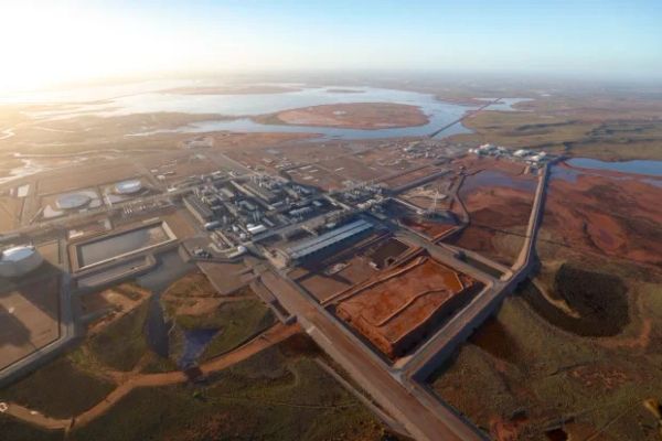 Aerial view of an industrial complex near wetlands at sunrise.