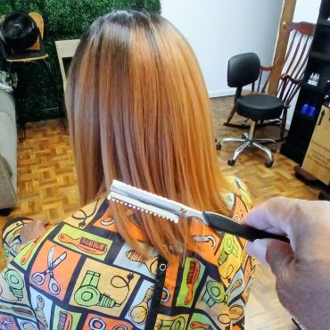 A person getting a haircut with a thinning razor.