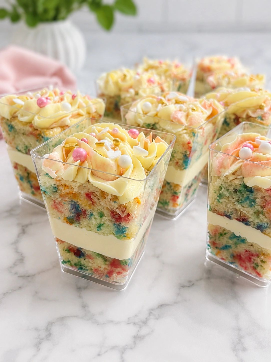 Colorful confetti cake dessert cups with creamy frosting and sprinkles.